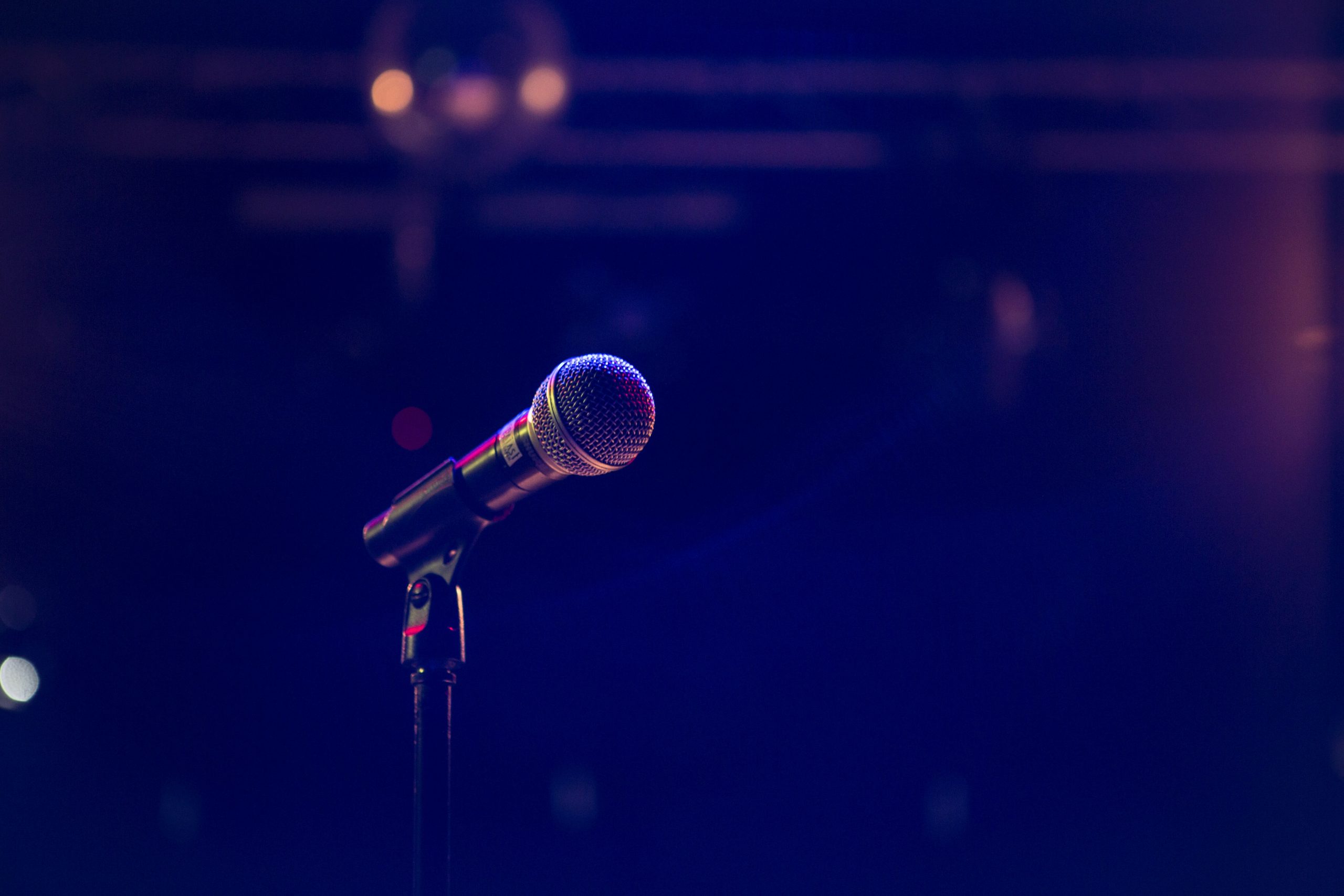 darkly lit microphone on an empty stage